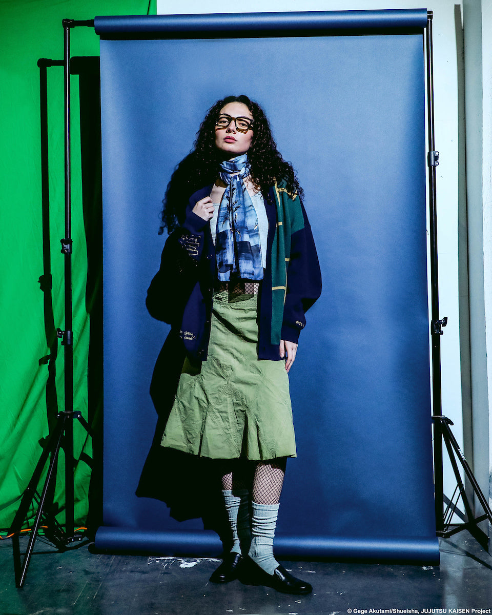 Full front view of a female modeling the Jujutsu Kaisen Cursed Spirit Manipulation Cardigan on set with blue, green ,and white background.