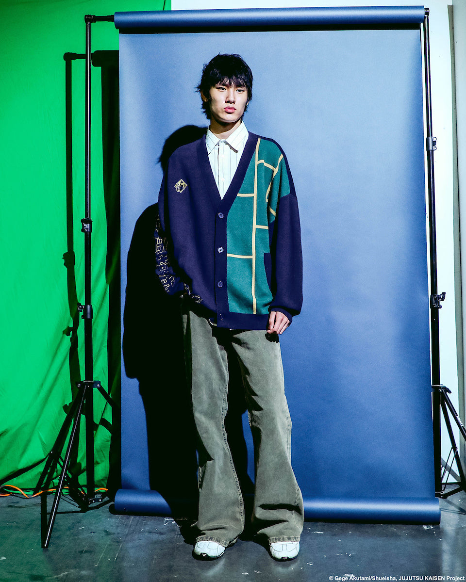 Full front view of a male modeling the Jujutsu Kaisen Cursed Spirit Manipulation Cardigan on set with blue , green and white background.