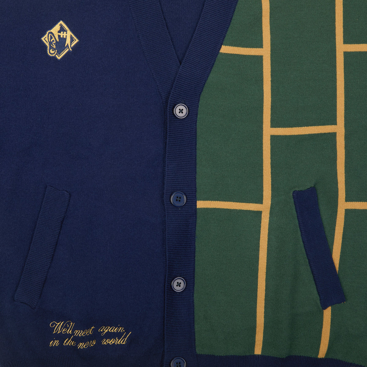 Close up of the buttons, patch and embroidered text on the Jujutsu Kaisen Cursed Spirit Manipulation Cardigan in navy blue with a green and yellow grid pattern.