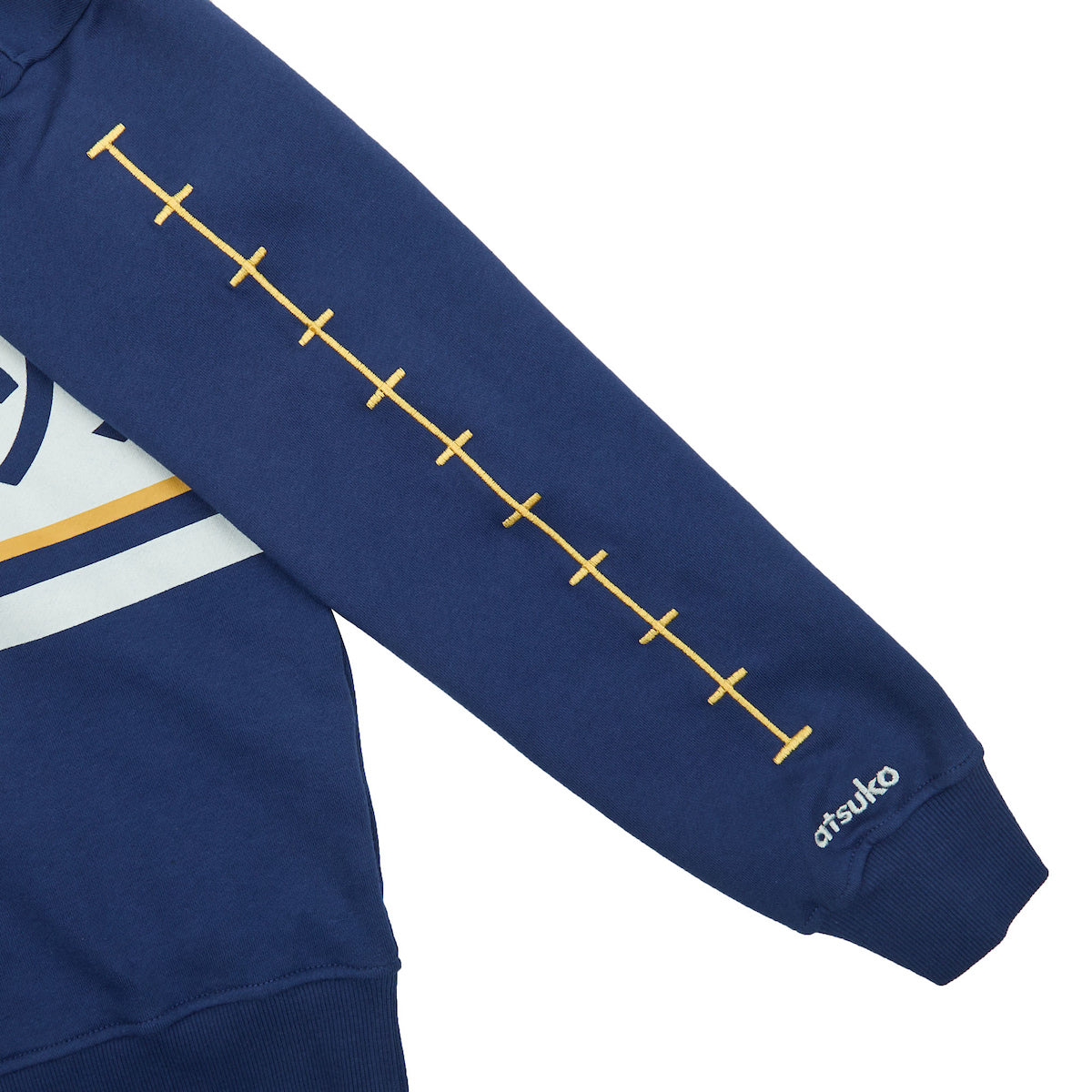 Close-up of the yellow embroidery on the sleeve Atsuko Kento Nanami Blue & Yellow Quarter-Zip Pullover with a navy blue base.